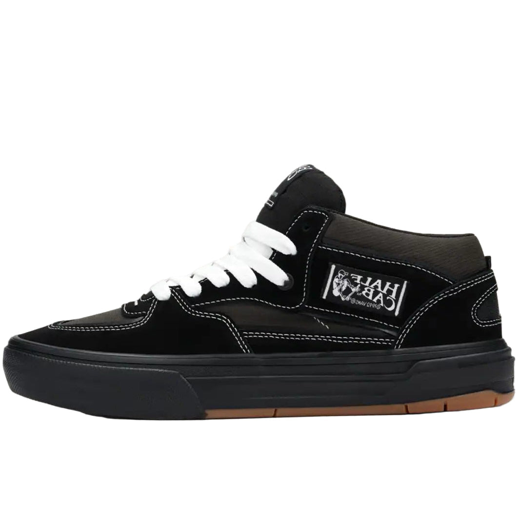 Black sneaker with white laces on a beige background