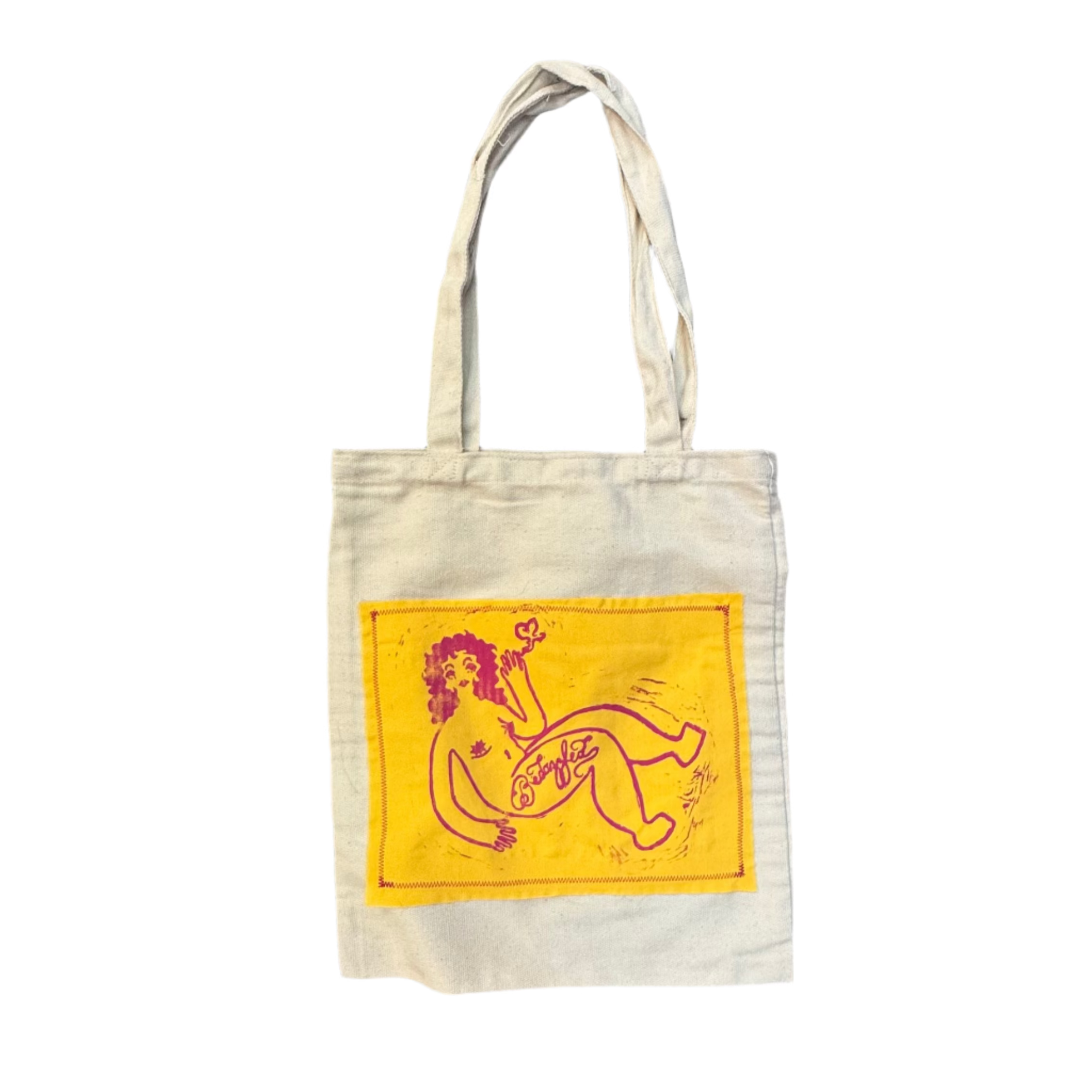 White tote bag with yellow graphic on a gray surface