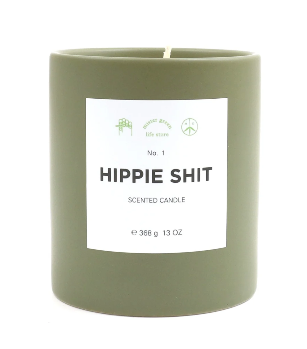 Green candle with a label reading 'Hippie Shit' on a white background
