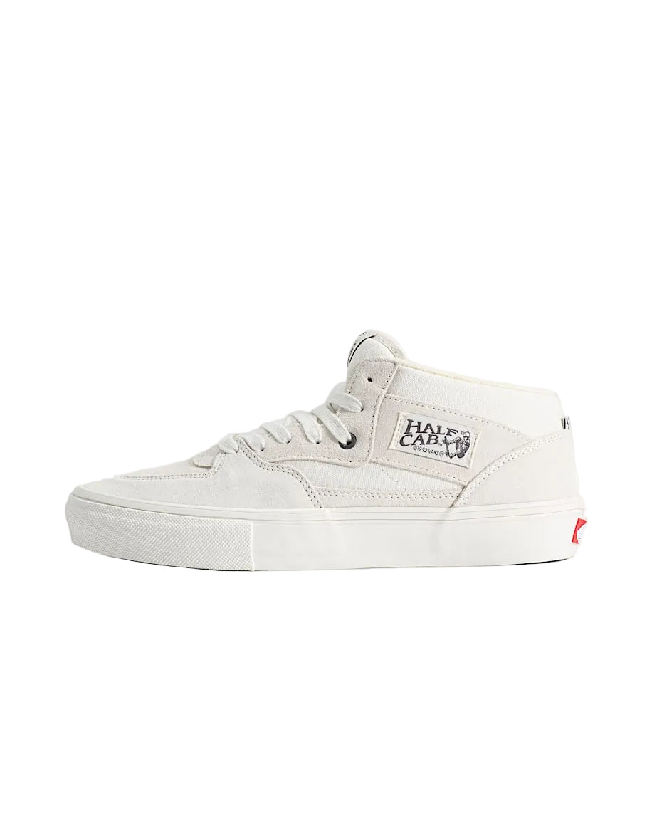A white mid-top skate shoe by Half Castle, shown in a side profile against a solid light beige background.