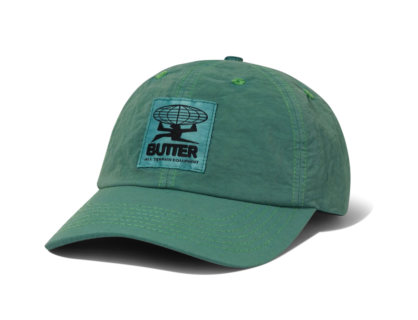 A green cotton twill baseball cap featuring a light blue rectangular patch on the front with a black satellite graphic and the text 'BUTTER GET YOUR OWN KINGDOM'.