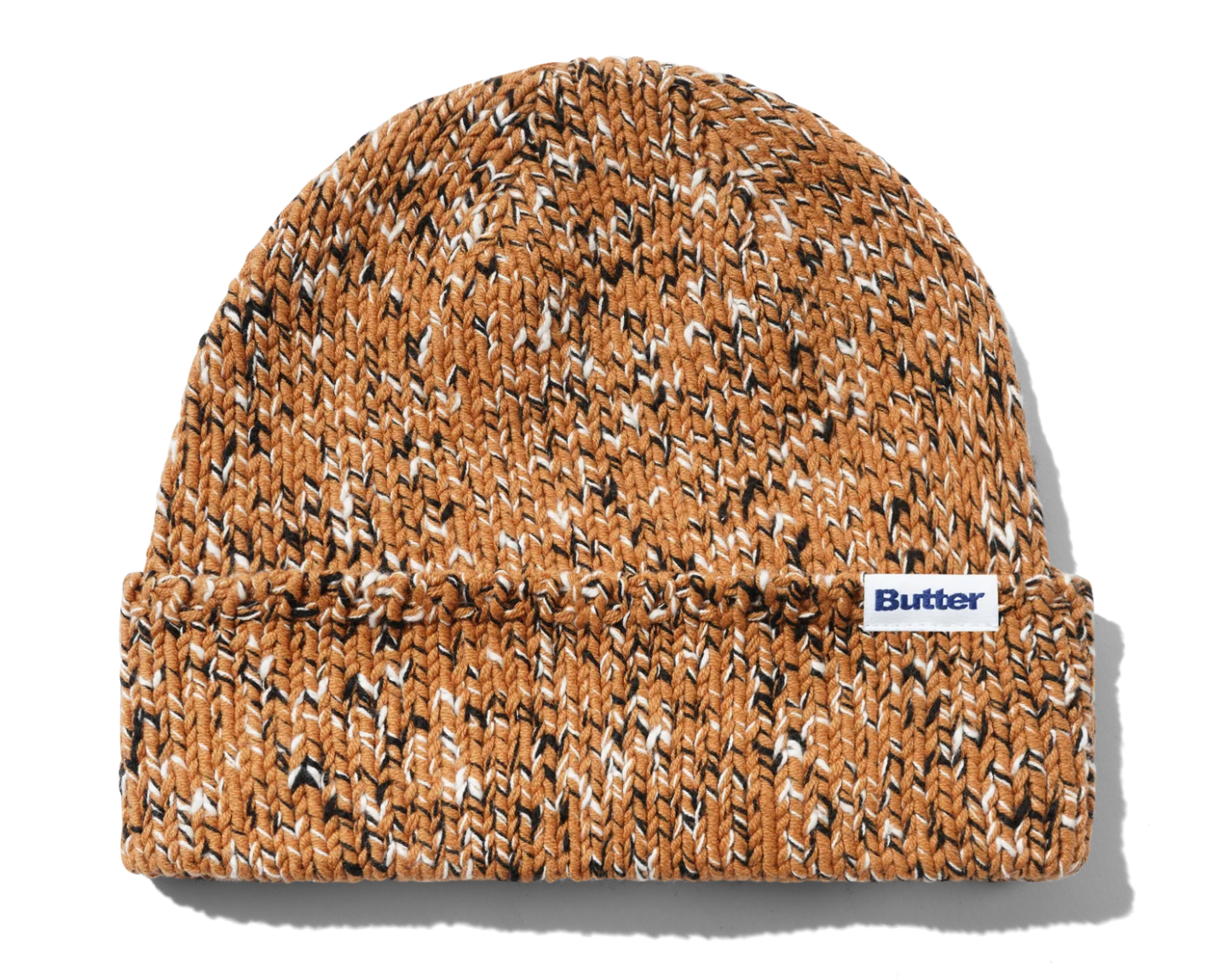 A marled knit beanie hat in a warm tan and brown colorway with black and white flecks, featuring a folded cuff and a small white 'Butter' brand label on the side, set against a plain white background.