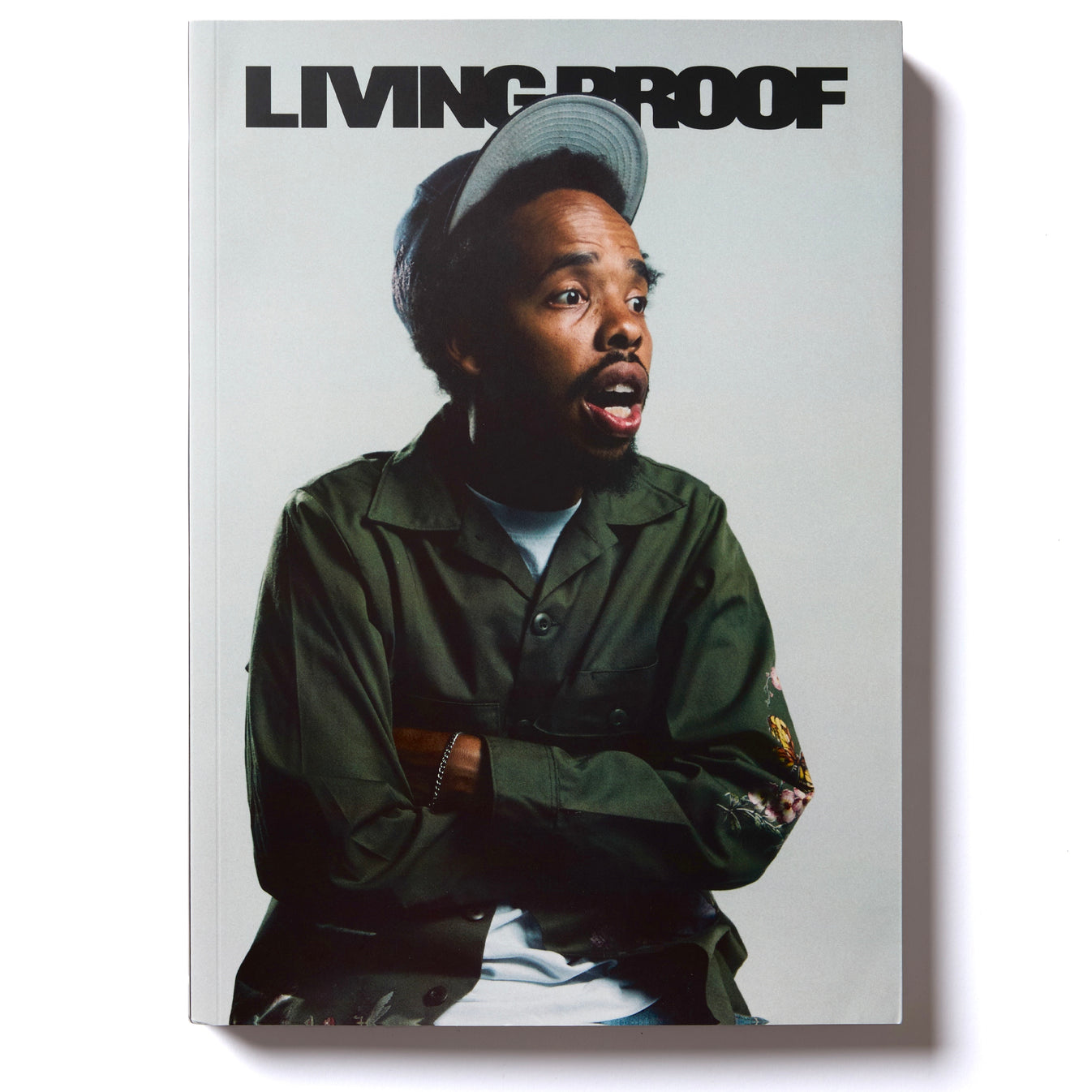 Book cover with a person wearing a green jacket and cap, titled 'Living Proof'.