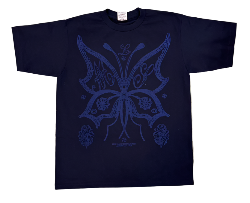 Navy blue t-shirt with a blue butterfly design on a tiled floor.